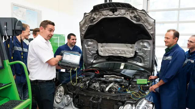 Skupina lidí účastnící se školení v autoservisu